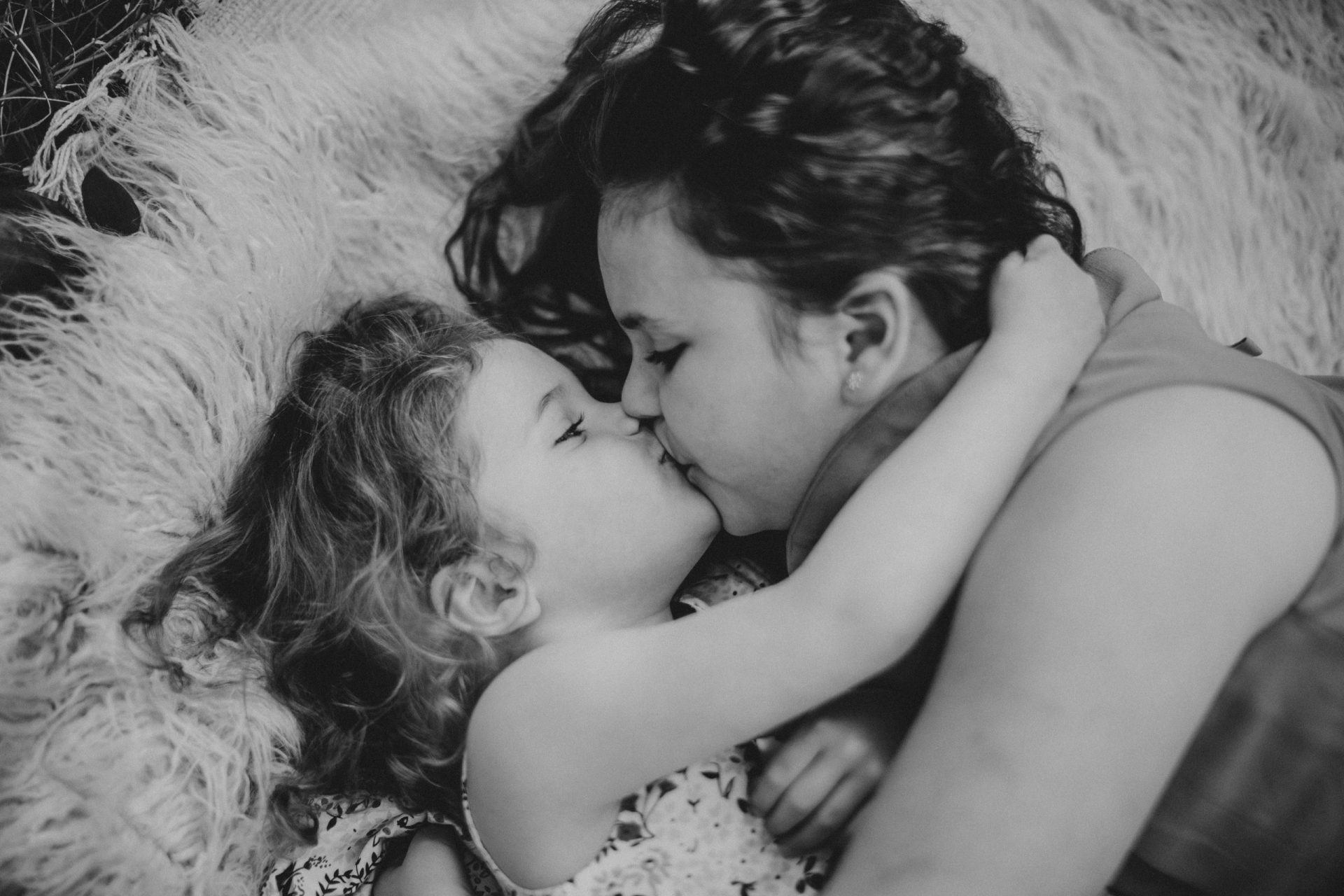 Fotografía en blanco y negro de niñas dándose un beso